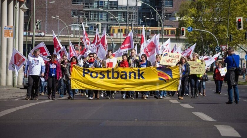 Demonstrationszug mit Postbank-Banner und ver.di-Flaggen