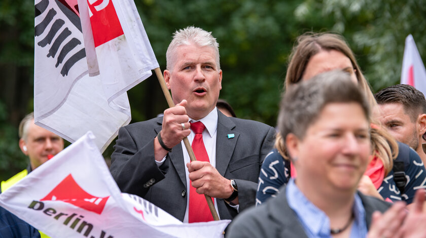 Mehrere ver.di-Aktive, die Fahnen in den Händen halten