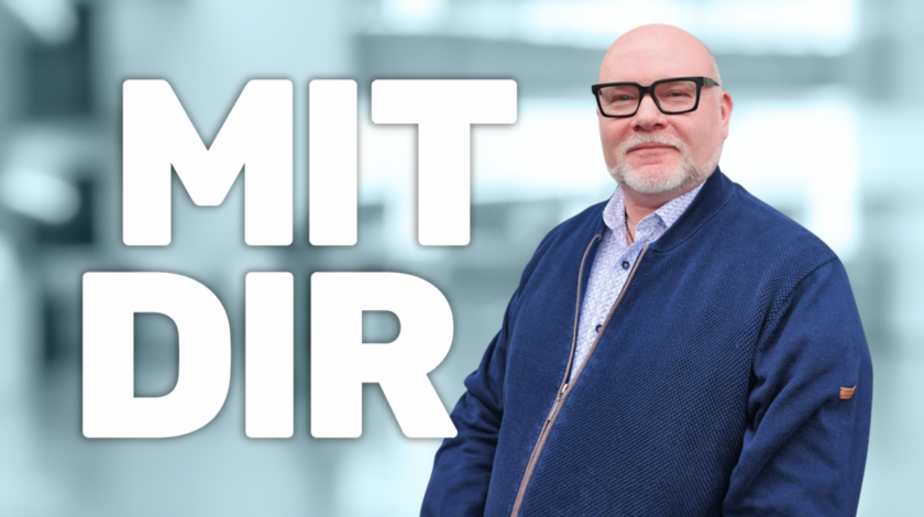 Der Schriftzug Mit Dir wird von einem älteren Mann der in die Kamera guckt begleitet